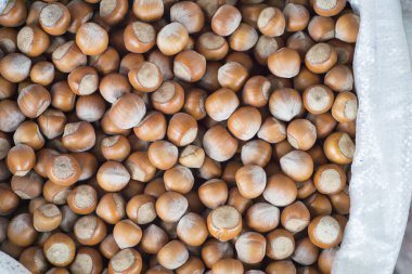 Tezgahtaki polipropilen beyaz poşette seçilmiş fındıklar. Geçmişi. Yukarıdan görünüşü.