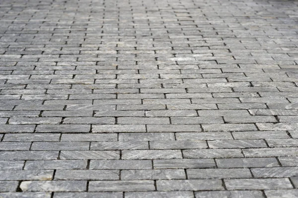 The sidewalk is made of rectangular gray granite bricks . Background — Stock Photo, Image