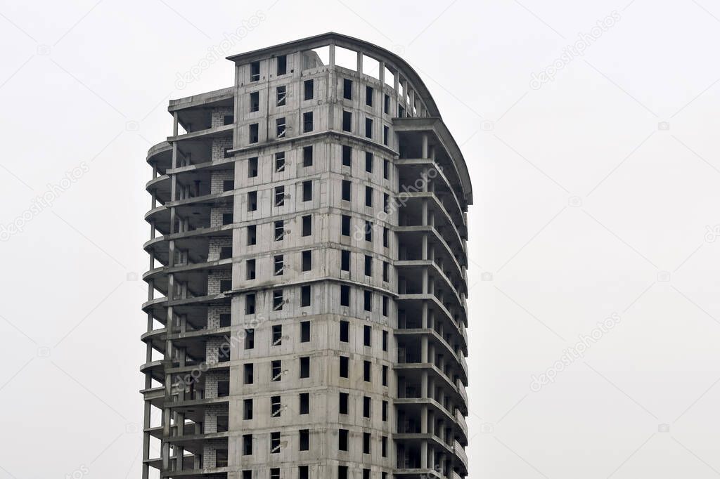 Concrete gray high-rise building partially without external walls. Background.