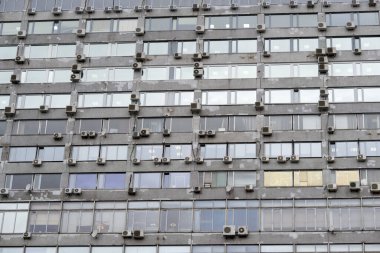 Büyük gri bir ofis binasının duvarı çeşitli markaların klimalarıyla doludur, Rusya, Moskova, Mart 2020.