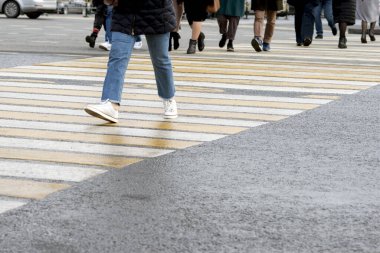 İnsanlar kavşaktaki yaya geçidinde karşıdan karşıya geçiyorlar. Arkaplan.