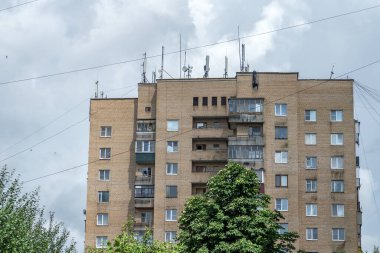 Yüksek bir binanın çatısında gri gökyüzüne karşı bir sürü anten ve kablo var. Modern yaşam için farklı bilgi gereksinimi kavramı.