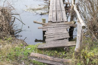 Sonbaharda köyde küçük bir nehrin üzerindeki tahta köprü. Geçmişi. Ulaşılması zor yerlerde köy hayatının yolu.