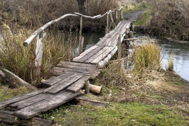 Sonbaharda köyde küçük bir nehrin üzerindeki tahta köprü. Geçmişi. Ulaşılması zor yerlerde köy hayatının yolu.