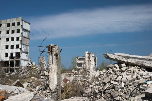 Os restos de um edifício destruído contra um céu azul texturizado — Fotografia de Stock