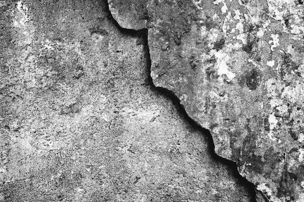 Betonmauer mit einer teilweise abgetragenen Oberflächenschicht mit einem schönen lockigen Rand. Hintergrund. Schwarz-Weiß-Bild. — Stockfoto