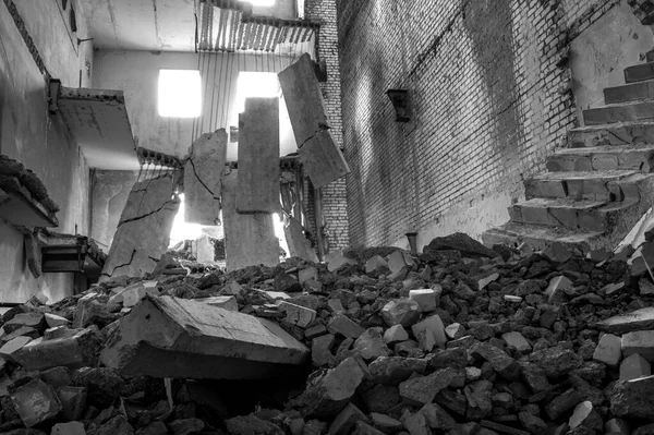 Destroyed concrete building inside with a pile of construction debris in the foreground. Background. — Stock Photo, Image