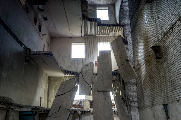 Edificio in calcestruzzo distrutto all'interno con un mucchio di detriti in primo piano. Contesto. — Foto Stock