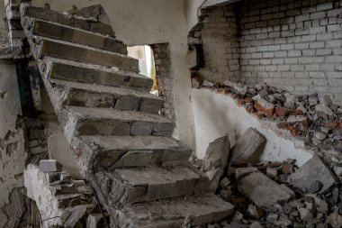 Binanın içinde kırık tuğlalar ve inşaat enkazı olan kırık bir beton merdiven. Arkaplan.