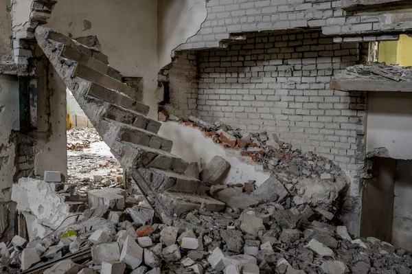 A broken concrete staircase with a pile of broken bricks and construction debris inside the building. Background.