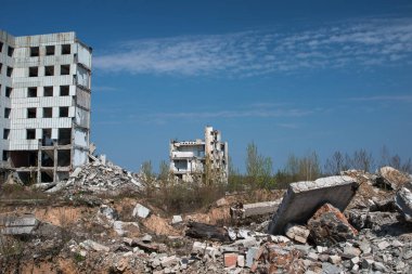 Yıkılmış bir binanın kalıntıları mavi gökyüzüne karşı.