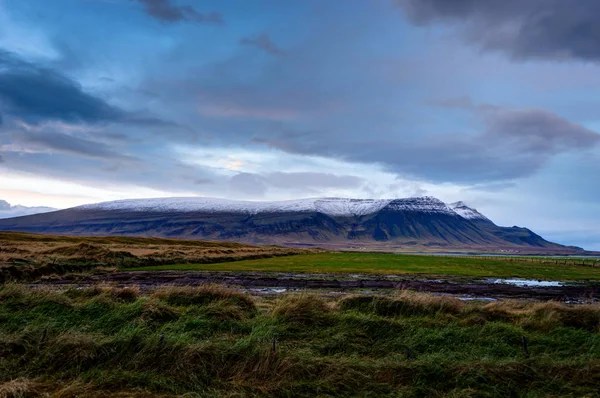 Зеленая трава с покрытыми снегом горами Исландский ландшафт durin — стоковое фото