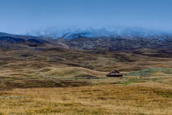 Casa solitária em Islandês Paisagem com nevoeiro montanhas com neve — Fotografia de Stock