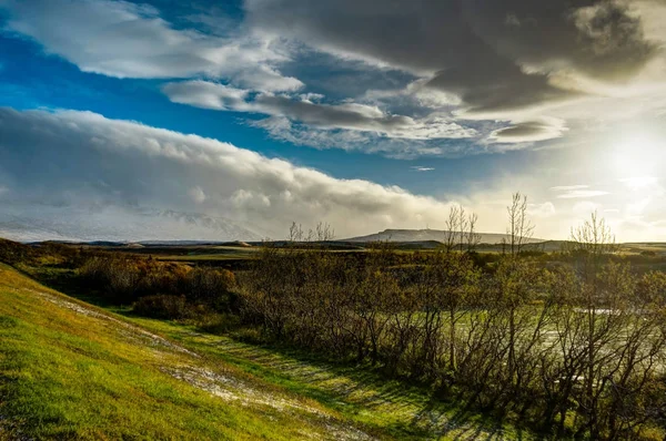 Isländska landskapet med blå himmel och sol och moln med mounta — Stockfoto