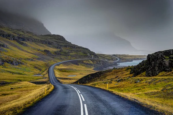 Calle vacía con paisaje islandés durante con montaña brumosa — Foto de Stock