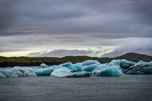 Iceberg galleggianti nel lago ghiacciaio di Jokulsarlon al tramonto a Icela — Foto Stock