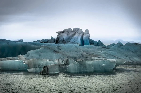 Icebergs flotando en el lago glaciar Jokulsarlon al atardecer en Icela —  Fotos de Stock