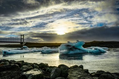 Günbatımı altın saatte glac ile Jokulsarlon içinde yüzen buzdağı