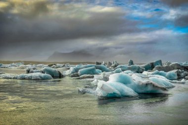 Icebergs floating in Jokulsarlon at sunset golden hour with glac clipart