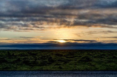 Altın saat sırasında yeşil yosun ile İzlanda manzara üzerinden günbatımı
