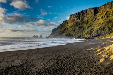 Siyah plaj ve deniz-yığınlar Vik İzlanda dağlar dalgalar ile bir