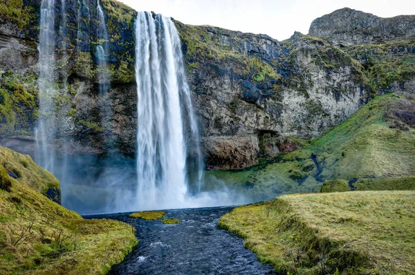 Водопад Seljalandsfoss в Исландии с горами и голубым небом — стоковое фото
