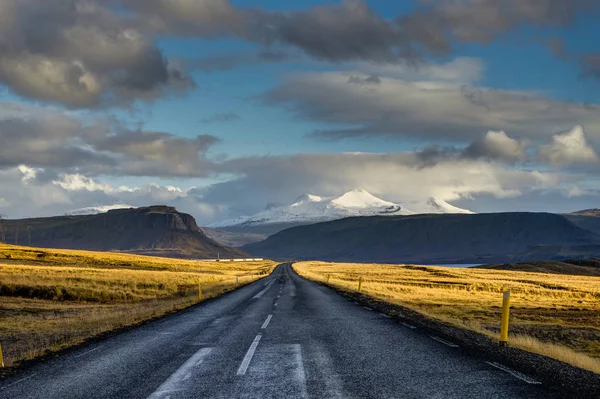 Calle vacía durante la hora dorada en Islandia con cielo azul y clo — Foto de Stock