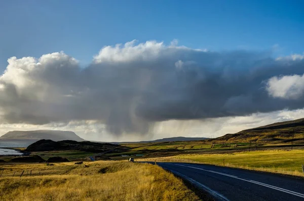 Calle vacía durante la hora dorada en Islandia con cielo azul y clo —  Fotos de Stock