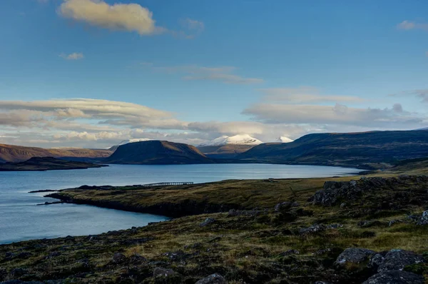 Islândia vista sobre a água para as montanhas com céu azul e clou — Fotografia de Stock