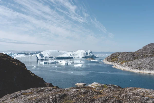 Άποψη προς Icefjord στο Ilulissat. Παγόβουνα από παγετώνα Kangia στη Γροιλανδία που κολυμπούν με μπλε ουρανό και σύννεφα. Σύμβολο της υπερθέρμανσης του πλανήτη. — Φωτογραφία Αρχείου