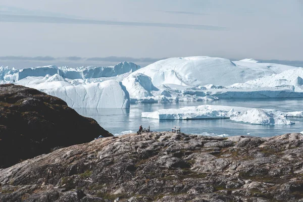 Vista verso Icefjord in Ilulissat. Iceberg dal ghiacciaio Kangia in Groenlandia nuotano con cielo blu e nuvole. Simbolo del riscaldamento globale . — Foto Stock