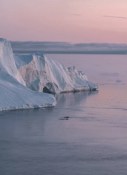 Arktische Naturlandschaft mit Eisbergen im grönländischen Eisfjord mit Mitternachtssonne und Sonnenuntergang am Horizont. Frühmorgendliches Alpenglühen während der Mitternachtszeit. Ilulissat, Westgrönland. — Stockfoto