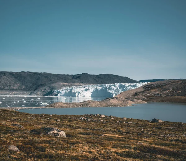 Groenlandse gletsjer met zeeijs en een gletsjerlandschap bij de Eqip Sermia gletsjer, Eqi in West-Groenland nabij Ilulissat. Blauwe lucht op een zonnige dag. Kalfgletsjer. — Stockfoto
