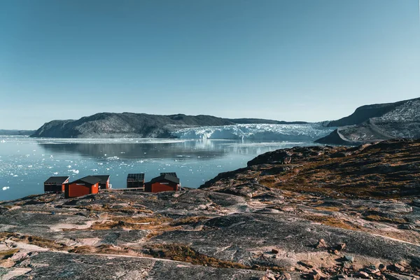 Panoramisch beeld van Camp Eqi op de Eqip Sermia gletsjer in Groenland. natuurlandschap met hutten. Middernachtzon en roze hemel. Toeristische bestemming Eqi gletsjer in West Groenland AKA Ilulissat en — Stockfoto