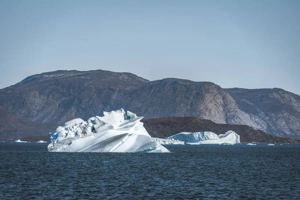 Ogromna pływająca góra lodowa w głębokiej błękitnej wodzie oceanu. Grenlandia i Antarktyda, niedaleko Ilulissat. Koncepcja globalnego ocieplenia. Błękitne niebo i fiord lodowy. — Zdjęcie stockowe