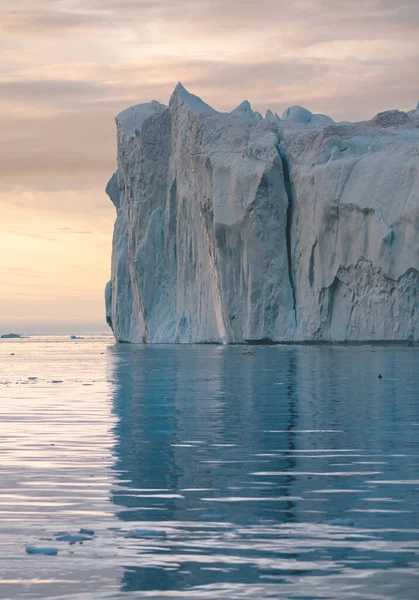 Iceberg al atardecer. Naturaleza y paisajes de Groenlandia. Disko Bay. Groenlandia Occidental. Sol de medianoche de verano y témpanos. Gran hielo azul en el fiordo de hielo. Afectados por el cambio climático y el calentamiento global . — Foto de Stock