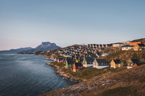 Grönland 'ın Nuuk başkenti ve Sunset Sunrise Midnight Sun sırasında Myggedalen' da küçük renkli evler. Arka planda Sermitsiaq Dağı. Mavi ve pembe Gökyüzü.
