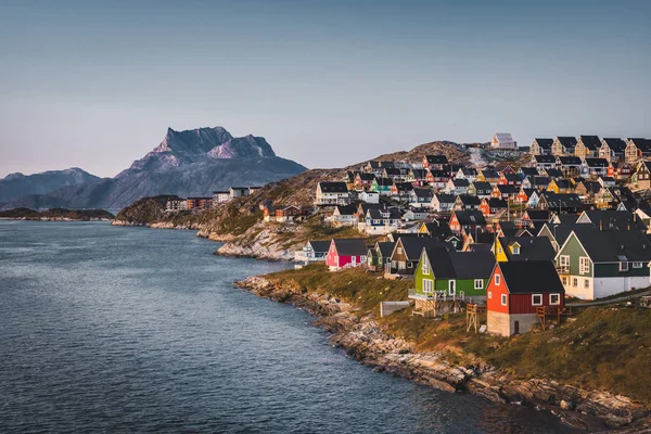 Нуук, столица Гренландии, с маленькими разноцветными домами в загадочных местах во время заката солнца. Гора Сермицяк в фоновом режиме. Голубое и розовое небо . — стоковое фото