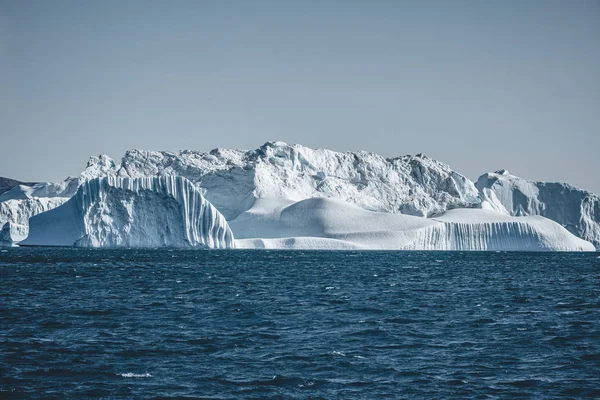 Antarktika 'da güneşli bir gün. Derin ve berrak sulardaki buzdağlarının yansıması. Buzların arasında gemi ile seyahat et. Antarktika adalarının kar ve buzları. — Stok fotoğraf
