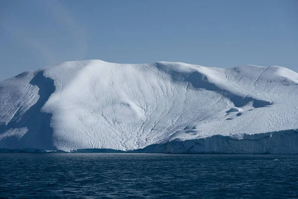 Ljus solig dag i Antarktis. Fullt lugn och spegling av isberg i djupt klart vatten. Res med fartyget bland isarna. Snö och is på de antarktiska öarna. — Stockfoto