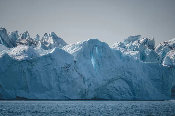 Brillante día soleado en la Antártida. Calma total y reflejo de icebergs en aguas profundas y claras. Viaja en barco entre hielos. Nieve y hielos de las islas Antárticas. — Foto de Stock