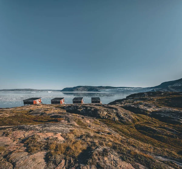 Panoramic image of Camp Eqi at Eqip Sermia Glacier in Greenland. nature landscape with lodge cabins. Midnight sun and pink sky. Tourist destination Eqi glacier in West Greenland AKA Ilulissat and — Stock Photo, Image