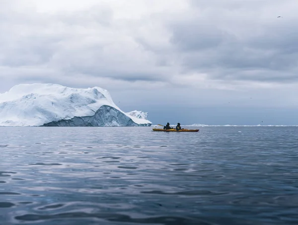 GREENLAND, Ilulissat - 7 de agosto de 2019: Personas en kayaks de mar observando una aleta de ballena jorobada. Hasta siete especies de ballenas visitan regularmente la zona . —  Fotos de Stock