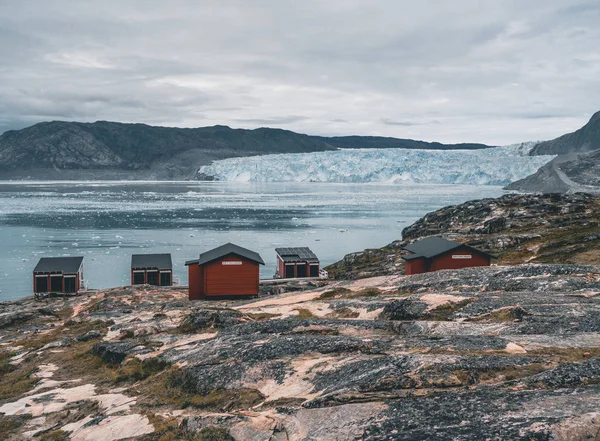 Imagem panorâmica do Campo Eqi no Glaciar Eqip Sermia, na Gronelândia. paisagem de natureza com cabanas de alojamento. Sol da meia-noite e céu rosa. Destino turístico Geleira Eqi na Gronelândia Ocidental AKA Ilulissat e — Fotografia de Stock