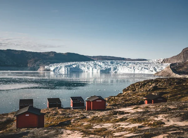 Панорамне зображення табору Екі на льодовику Екіп-Сермія в Гренландії. Природний ландшафт з хатинами. Сонце опівночі і рожеве небо. Туристичне місце Екі льодовик у Західній Гренландії АКА Ілулісат — стокове фото