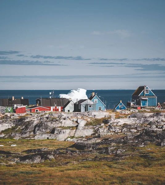 Pohled na barevné grónsko domy na ostrově Disko, arktické město Qeqertarsuaq. Nachází se v zátoce Disko. Modrá obloha a slunečný den. Stolní hory na pozadí. — Stock fotografie