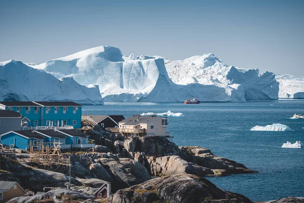 格陵兰Ilulissat北极城市的空中景观。夏天，一个阳光灿烂的日子，蓝天乌云密布，市中心的房子五彩缤纷，背靠着冰山 — 图库照片