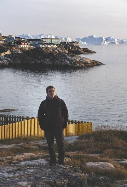 People sitting standing in front of huge glacier wall of ice. Icefjord Ilulissat. Jakobshaven Eqip Sermia Glacier Eqi glacier in Greenland called the calving glacier during midnight sun. Hikers during — ストック写真