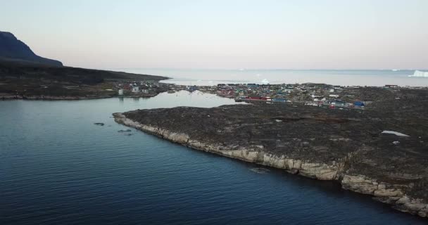 4K Aerial Drone flight in Disko Bay Greenland. Arctic city of Qeqertarsuaq in Disko Island. Colourful houses during sunset and midnight sun. Icebergs in Background. — ストック動画