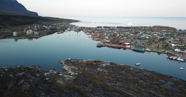 4k antenn drönare flygning i Disko Bay Grönland. Arktiska staden Qeqertarsuaq i Disko Island. Färgglada hus under solnedgången och midnattssolen. Isberg i bakgrunden. — Stockvideo